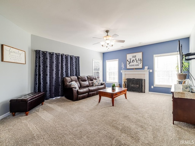 carpeted living room with plenty of natural light, a tile fireplace, baseboards, and a ceiling fan