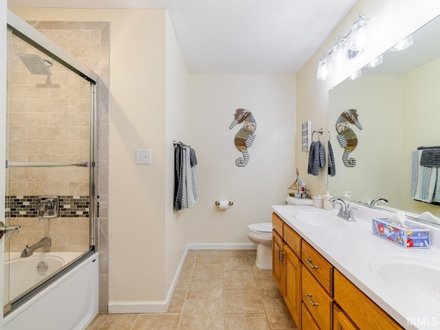 full bath with tile patterned floors, a sink, shower / bath combination with glass door, double vanity, and baseboards