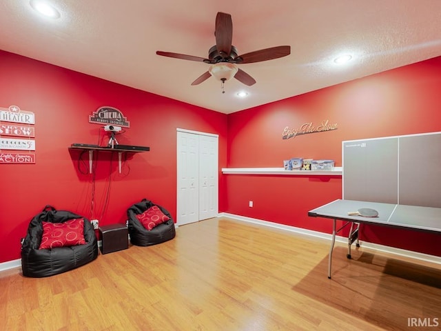 misc room with wood finished floors, baseboards, and ceiling fan