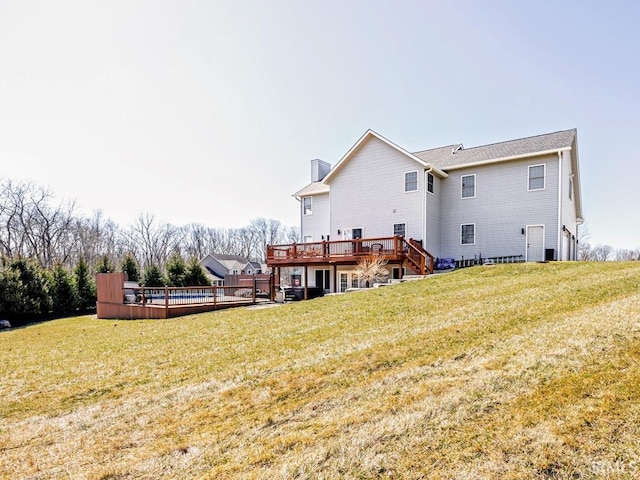 rear view of house featuring a lawn, a deck, and stairs