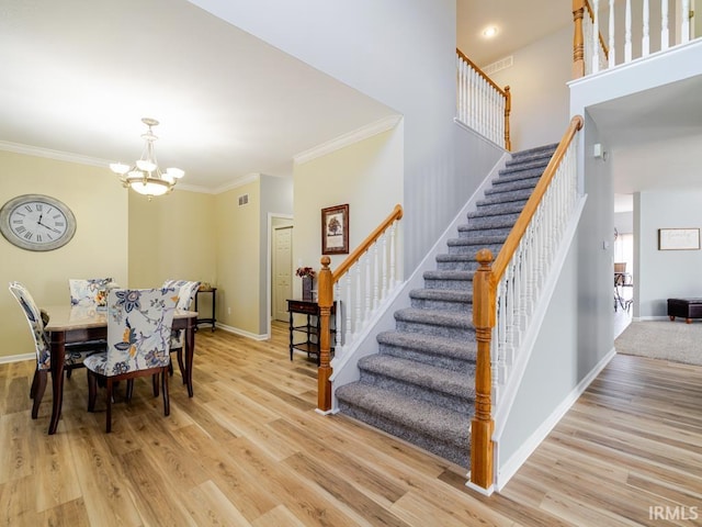 dining room with light wood-type flooring, baseboards, ornamental molding, and stairs