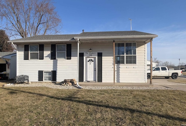 view of front of home featuring roof with shingles and a front lawn