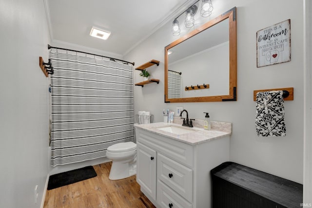 bathroom featuring vanity, toilet, wood finished floors, and ornamental molding