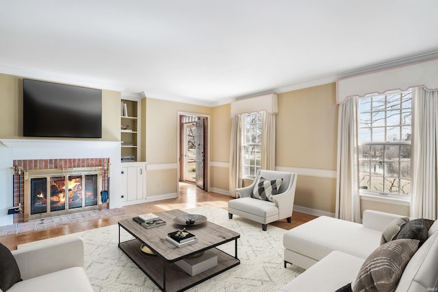 living area featuring a healthy amount of sunlight, ornamental molding, and a fireplace