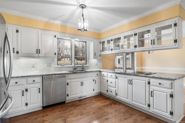 kitchen featuring appliances with stainless steel finishes, wood finished floors, crown molding, and a sink