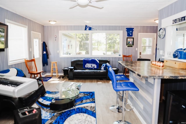 living area featuring baseboards, beverage cooler, wood finished floors, and a ceiling fan