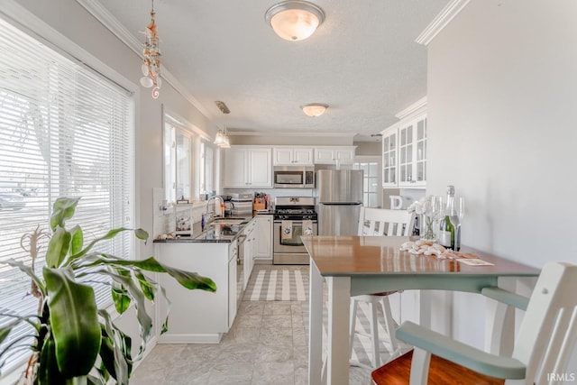 kitchen featuring a sink, appliances with stainless steel finishes, ornamental molding, and white cabinets