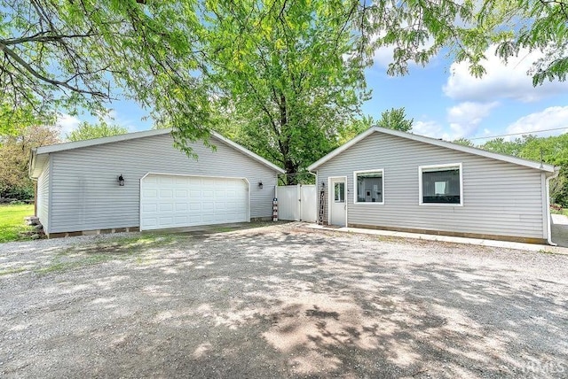 view of front of home with a garage and a gate