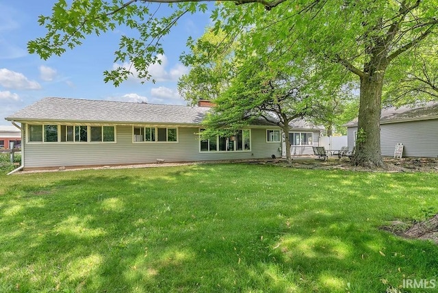 back of property featuring a yard