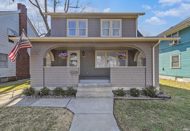 view of front of property with covered porch and a front lawn