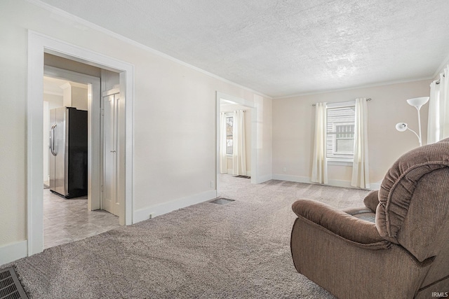 living area with visible vents, light carpet, a textured ceiling, and crown molding