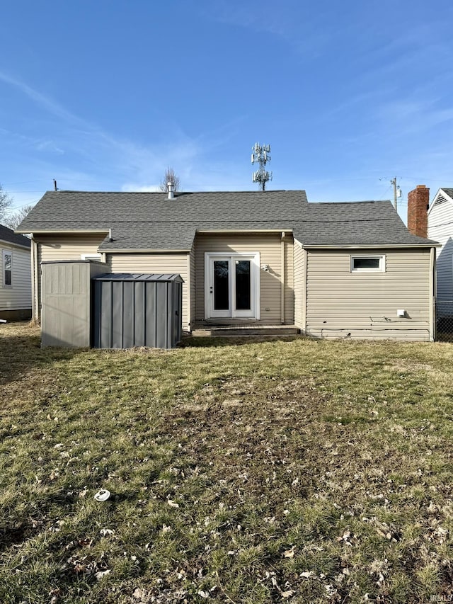 rear view of property featuring a yard and entry steps