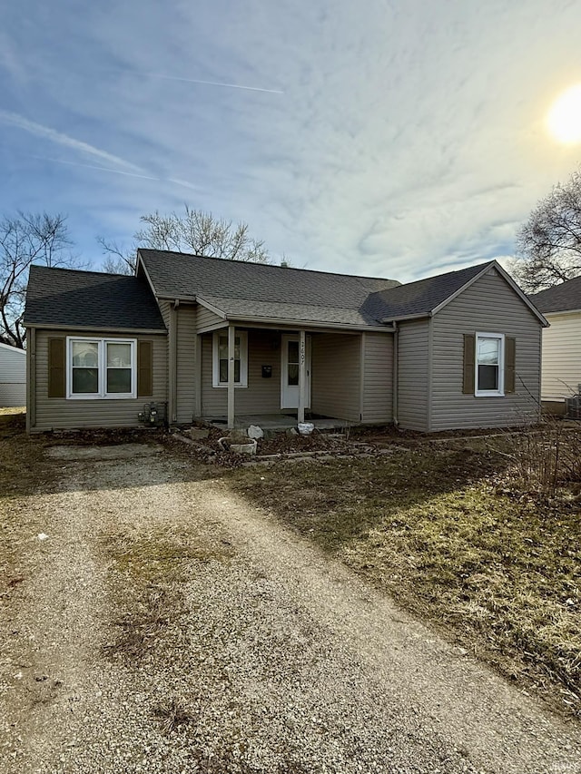 ranch-style house featuring a porch and dirt driveway