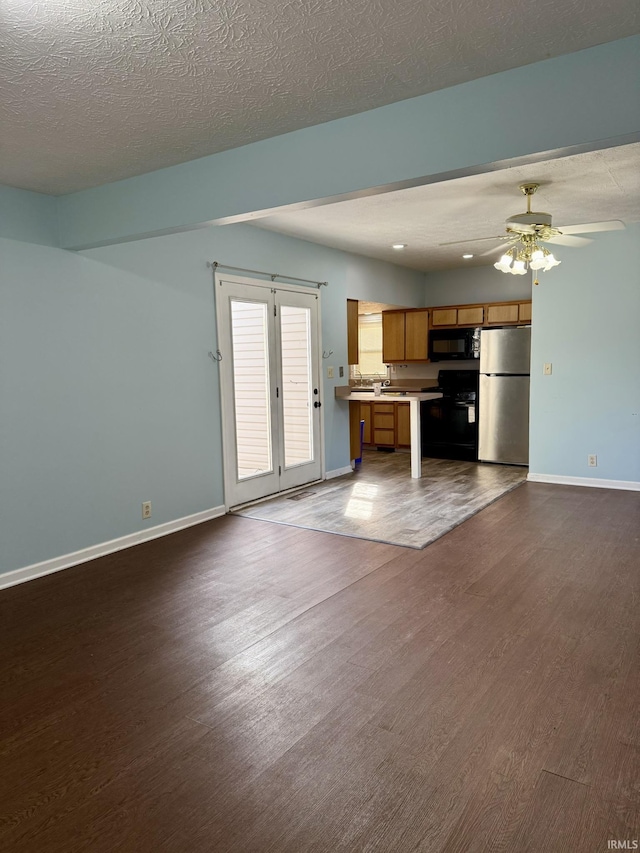 kitchen featuring dark wood-type flooring, open floor plan, light countertops, brown cabinets, and black appliances