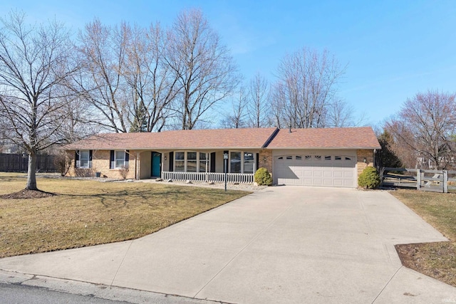 ranch-style house with fence, an attached garage, covered porch, a front lawn, and concrete driveway