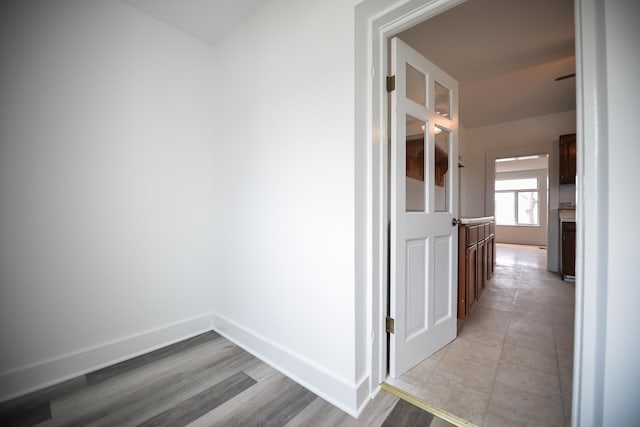 hallway featuring light wood-style floors and baseboards