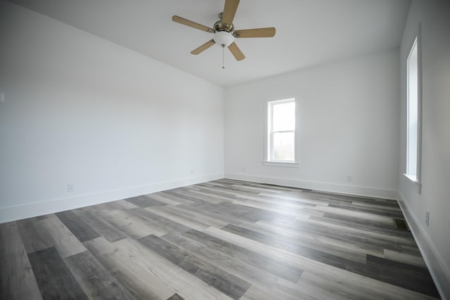 spare room featuring visible vents, baseboards, and wood finished floors