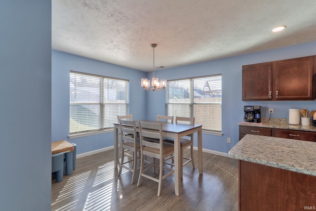 dining room with a healthy amount of sunlight, baseboards, an inviting chandelier, and wood finished floors