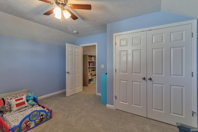 bedroom with baseboards, ceiling fan, light colored carpet, lofted ceiling, and a textured ceiling