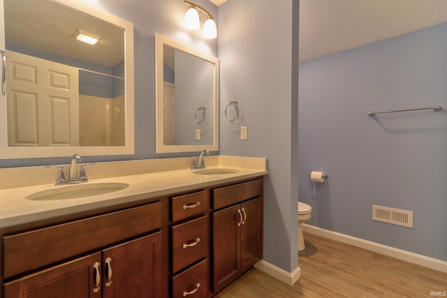 full bathroom featuring a sink, visible vents, toilet, and wood finished floors