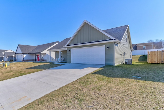 ranch-style house with board and batten siding, central AC, a front yard, driveway, and an attached garage