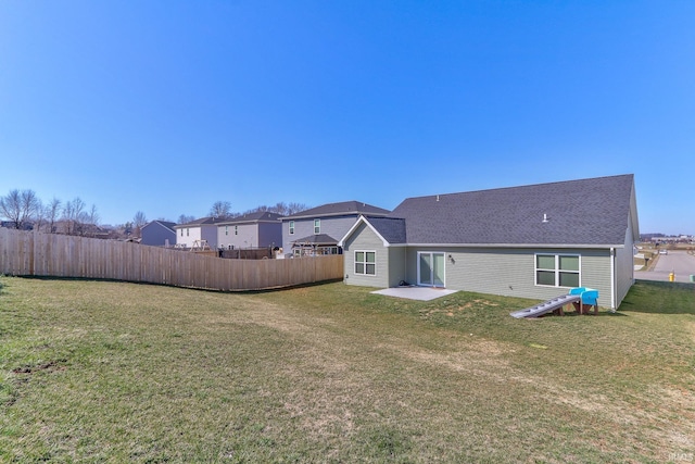 back of property featuring fence and a lawn