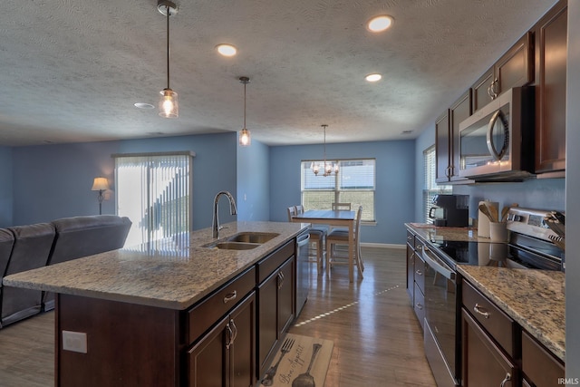 kitchen with a sink, stainless steel appliances, plenty of natural light, and dark wood-type flooring