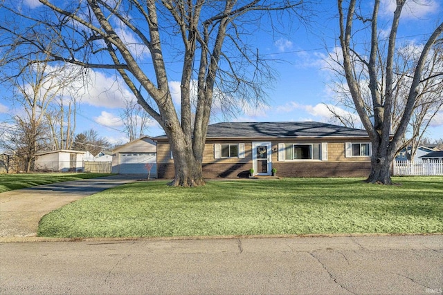 view of front facade with a front yard, fence, and brick siding