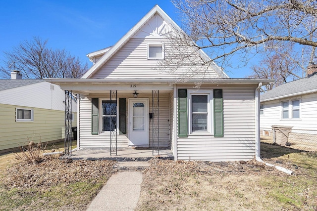 view of front of property with a porch and fence