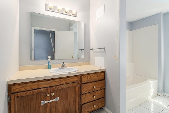 bathroom with tile patterned flooring, vanity, and a washtub