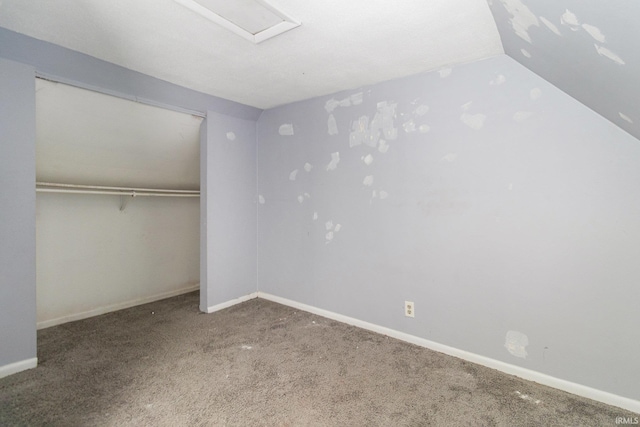 unfurnished bedroom with vaulted ceiling, carpet flooring, baseboards, and a closet