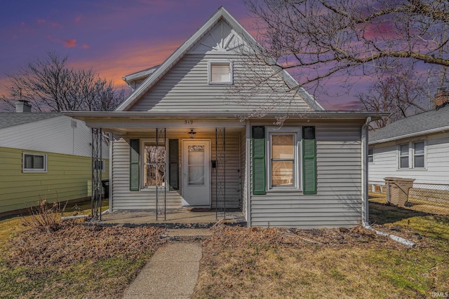 bungalow with covered porch and fence