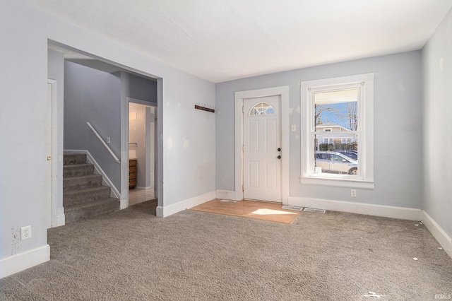 entryway featuring stairway, visible vents, baseboards, and carpet floors