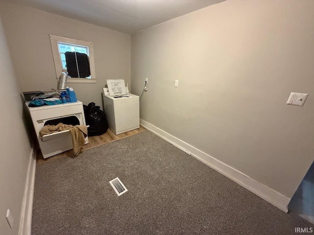 washroom with wood finished floors, visible vents, baseboards, carpet floors, and washer / clothes dryer