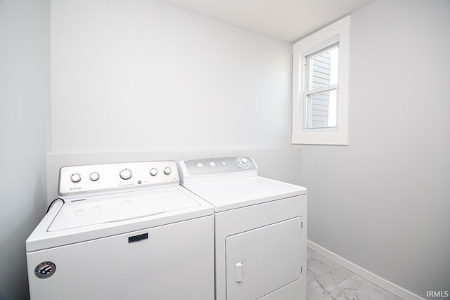 laundry room featuring baseboards, marble finish floor, laundry area, and washing machine and clothes dryer