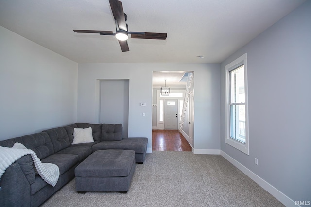 carpeted living room featuring baseboards and ceiling fan