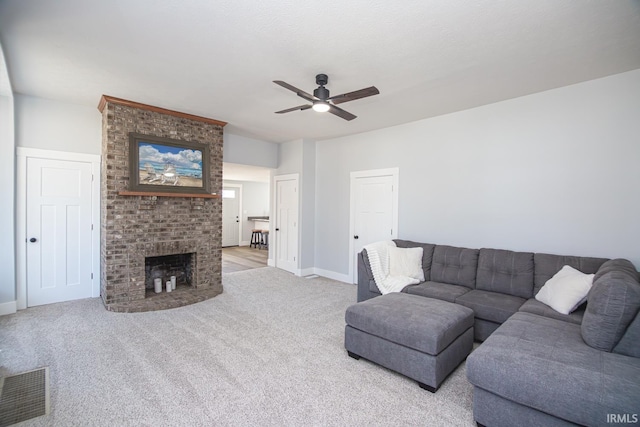 living room with carpet, a fireplace, visible vents, and a ceiling fan