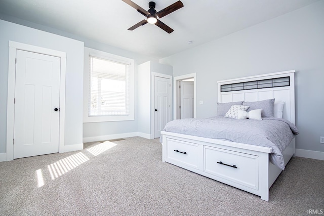 bedroom featuring light carpet, a ceiling fan, and baseboards