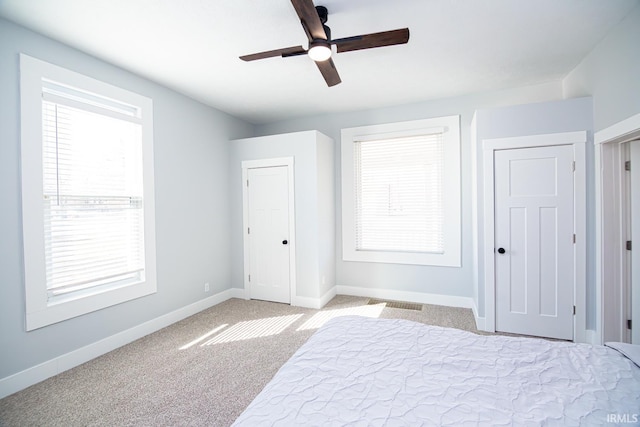 unfurnished bedroom with baseboards, carpet floors, and a ceiling fan