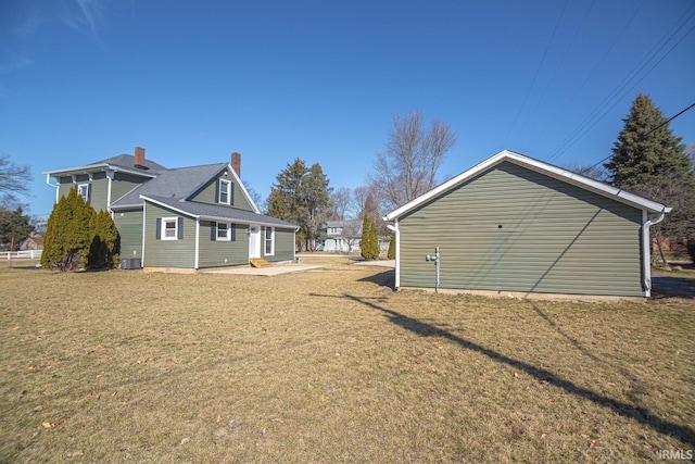 view of side of home featuring a lawn and central AC