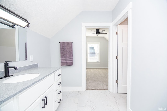 bathroom featuring lofted ceiling, marble finish floor, a textured ceiling, baseboards, and vanity