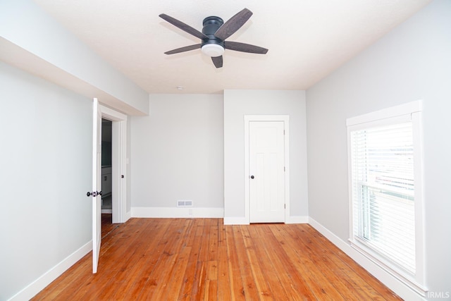 unfurnished bedroom featuring a ceiling fan, baseboards, visible vents, and light wood-type flooring