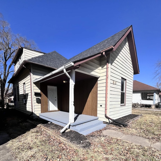 back of property with roof with shingles