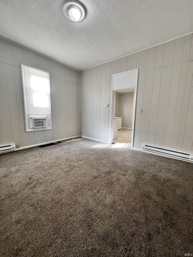 carpeted spare room with a baseboard heating unit, baseboards, a textured ceiling, and cooling unit