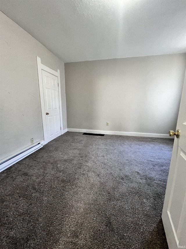 unfurnished room featuring a textured ceiling, baseboards, dark colored carpet, and a baseboard radiator