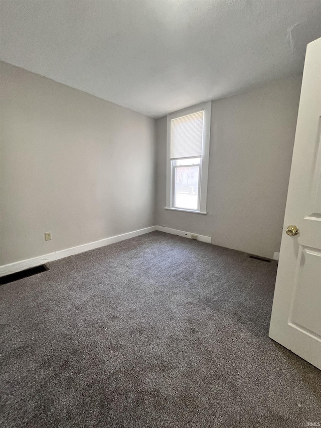 unfurnished room with visible vents, baseboards, and carpet floors