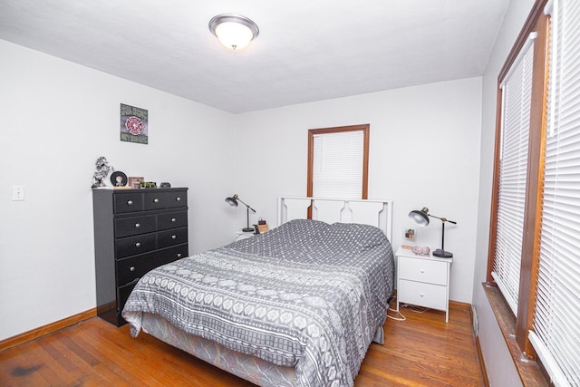 bedroom with wood finished floors and baseboards