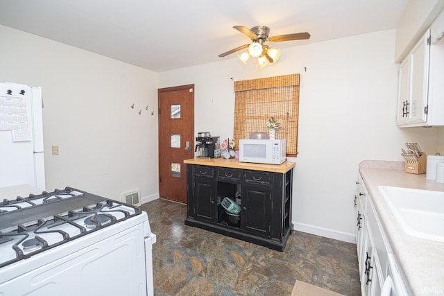 kitchen featuring visible vents, white appliances, light countertops, and dark cabinets