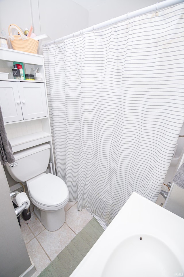 full bathroom featuring a shower with shower curtain, toilet, and tile patterned flooring