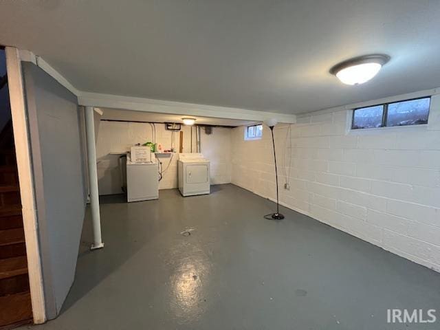 basement featuring concrete block wall and washer and clothes dryer